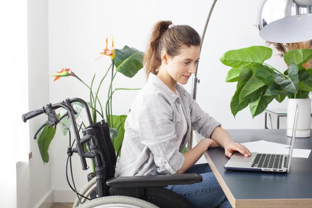 働く障害者イメージ　パソコンに向かう車椅子の女性